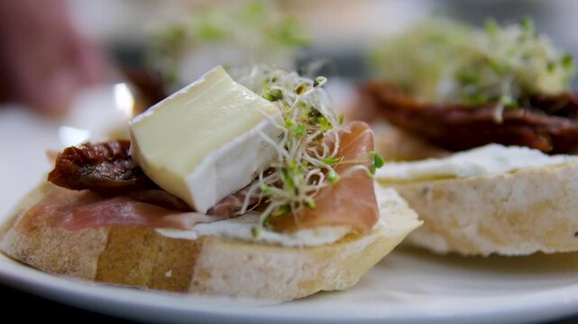 buffet snacks sandwiches with prosciutto balyk jamon and cheese on a plateSpanish food Iberico ham sandwich, Spanish bocadillo de jamon Iberico