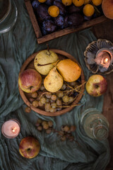 autumn fruits, still life, yellow pears, plums, peaches, still life outside, dinner outside, autumn mood, coziness, candles