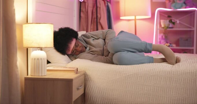 Relax, bed and black woman with tummy cramps for periods, menstruation or pms symptoms. Pain, stomach ache and African female person resting in bedroom with indigestion, IBS or endometriosis at home.