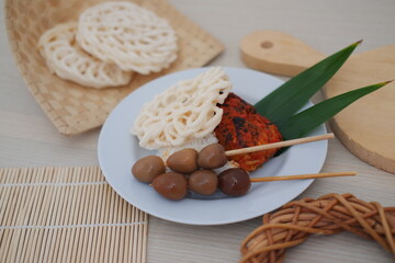 rice with skewered quail eggs and crackers on wood background. Selective focus.