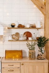 Scandinavian kitchen with a Christmas tree and a wooden shelf with various items on it, lit up with lights, creating a warm and cozy atmosphere