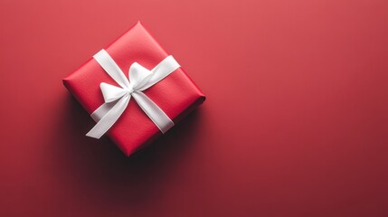 Elegant red gift box with white ribbon on red background