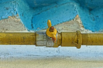 one iron ball gas round with yellow handle modern faucet with metal pipe located along the brick...