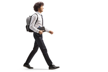 College student carrying a book and walking