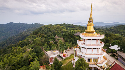 Fototapeta premium Aerial of Koh Samui island Thailand buddhist temple pagoda in top of the rainforest jungle hill near Lamai beach village 