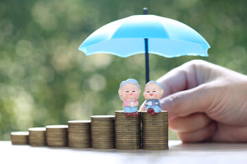 Mutual fund,Love couple senior and stack of coins money on natural green background, Save money for prepare in future and pension retirement concept