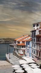 Obraz premium Disparo vertical de la hermosa villa pesquera de Cudillero en el litoral del mar Cantábrico, norte de España. Con cielo editado
