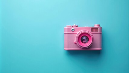 Fototapeta premium Pink retro camera placed on a minimal blue background, vintage, photography, nostalgic, technology, classic, pastel