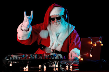 DJ Santa Claus mixing tracks in a nightclub at a Christmas and New Year party or Corporate events....