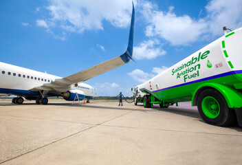 Sustainable Aviation Fuel (SAF) Technician refueling private jet with SAF at the airport.