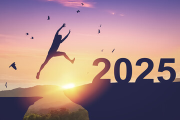 Obraz premium Silhouette man jumping between cliff to 2025 and birds flying at top of mountain. Freedom challenge and travel adventure holiday concept.