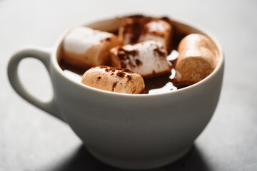 Cocoa drink with marshmallow in white cup on terrazzo surface