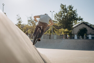 Sporty rider upgrading skills at outdoors skateboarding park in residential area