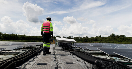 Fototapeta premium An African-American engineer carefully examines a cutting-edge floating solar panel system designed to harness renewable energy for an industrial complex.