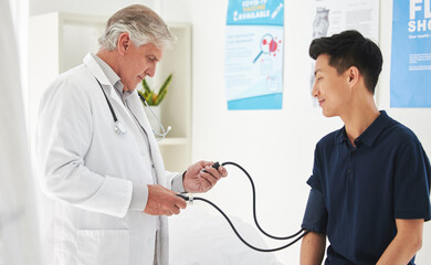 Doctor, patient and blood pressure with machine or monitor for medical examination, checkup or...