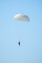Skydiving. Flying parachutists against the background of the blue sky and mountains. Extreme sport and entertainment.