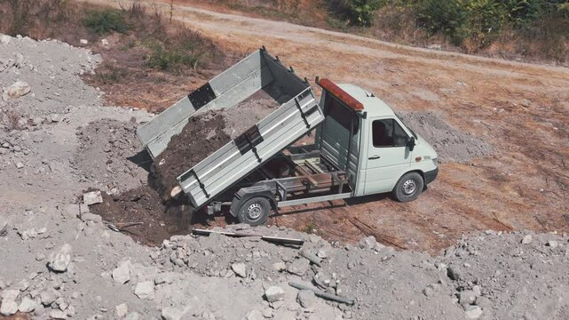 Small dump truck removes soil from a new construction site. Digging a pit, removing construction waste from a construction site