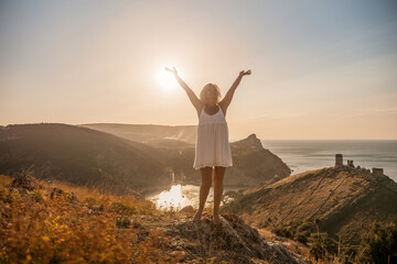 woman standing hill with her arms raised in the air, looking up at the sun. The scene is peaceful and serene, with the woman's expression conveying a sense of joy and happiness.