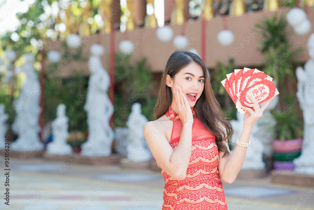 Wall mural beautiful asian woman wear cheongsam holding red envelope (red packet) with blessing phrase 