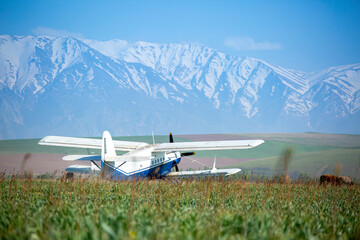 Fototapeta premium The plane flies over the fields, spraying the fields with insecticides for a good harvest.
