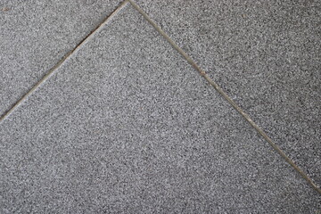 Fototapeta premium Close-up of grey tile floor with grout lines.