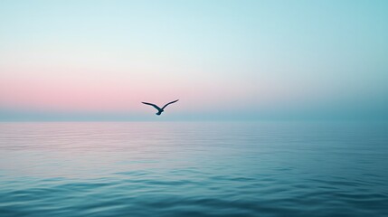 Fototapeta premium A single bird flying over a calm sea at dusk with a blue and pink sky, creating a peaceful and minimal scene.
