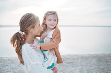 Mother, girl and carrying at beach for travel, bonding and relax with sunshine, sand and water....