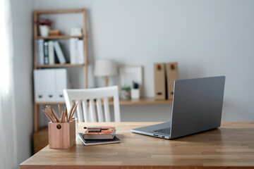 Mockup blank screen laptop computer on wooden table in living room.
