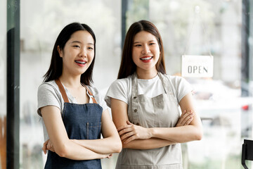 Small startup business owner concept. two successful young baristas women standing in bar counter in cafe.