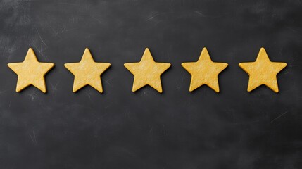 Fototapeta premium Five gold stars on blackboard background Five gold stars neatly arranged in a row on a blackboard background, symbolizing high quality, excellence, and top ratings