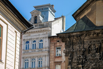 Contrast of building facades from different times: a modern house, a historical one and a very old one