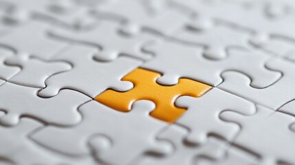 Fototapeta premium A single yellow puzzle piece stands out from the rest of the white puzzle pieces.