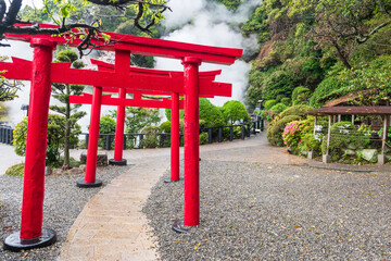 Red torii gates with white steam at Umi Sea Hell of Kamado Jigoku, Beppu