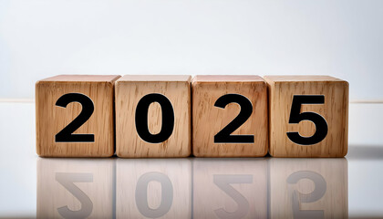 a wooden cubes displaying "2025," with a backdrop of a clean, white surface. The simplicity of the setup highlights the contrast between the natural wood texture and the crisp white background.