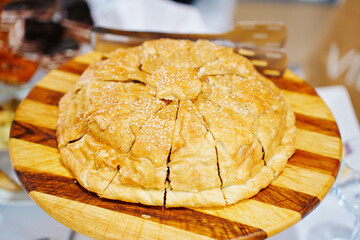 Traditional Russian pancake pie with chicken in puff pastry on a wooden tray.  © andrey