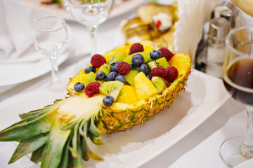 Pineapple stuffed with exotic fruits and berries. 