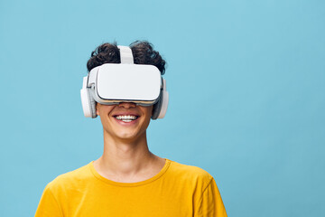 Virtual reality experience, happy young man with VR headset, enjoying technology against a light...