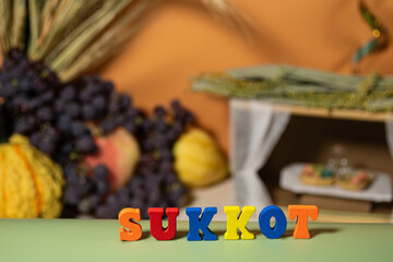Pumpkin, grape, wheat ears and tabernacle and wooden letters. Selective focus. Sukkot Feast concept.