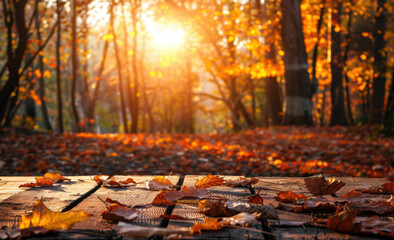 Beautiful autumn background with wooden table and golden leaves in forest, copy space for product display montage. Autumn landscape with blurred sunlight through trees.