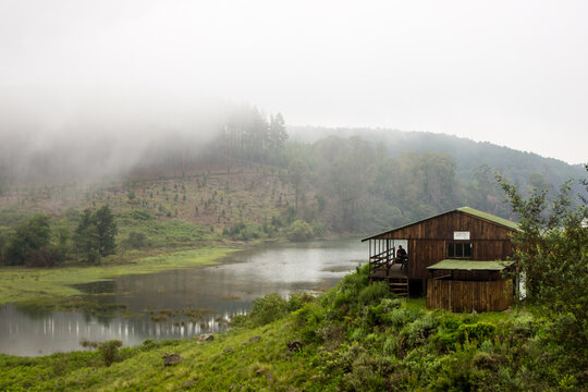 Early cold morning over a small lake in Magoebaskloof in South Africa, with the mountains in the background shrouded in mist.