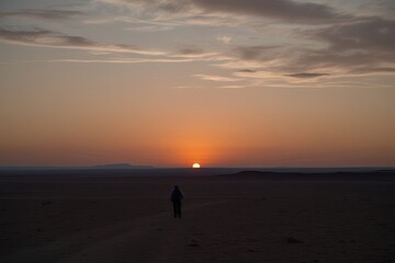 Naklejka premium Solo Journey Through Isolated Landscapes Exploring Desolate Plateaus at Dusk