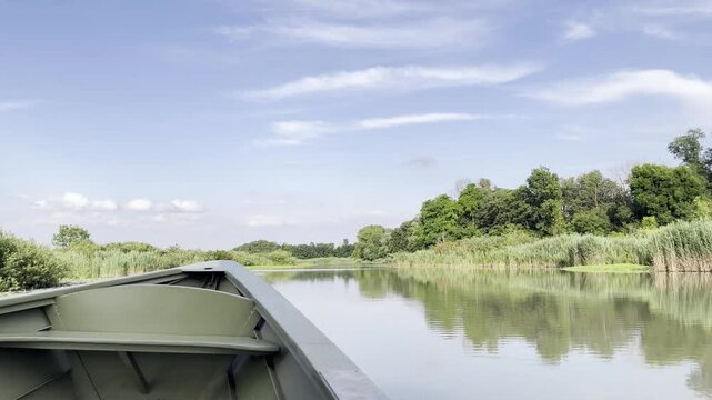Boat tour on the Italian River. Scene features a variety of plants thriving at the water's edge, highlighting the region's rich biodiversity