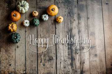 Happy Thanksgiving text with pumpkins and leaves over dark weathered wood background