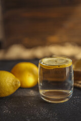 Cool freshly made lemonade in glass on wooden table. Space for text