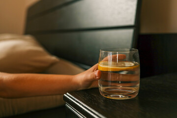Close up of woman's hand taking a glass of water