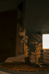A close-up of an extinguished candle with smoke rising from the wick, surrounded by melted wax
