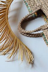 Fragment of a straw bag in natural colors with palm branches.