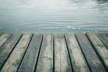 Fototapeta premium A wooden pier extending over calm water with gentle waves, evoking a sense of tranquility and solitude.