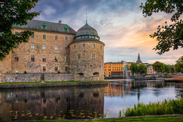 Medieval Orebro Castle is a fortification surrounded by Svartan river in sunset, light . Tourist atraction and history entusiast destination. Sweden. Copy space