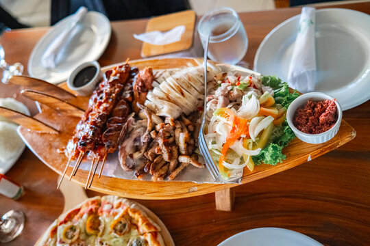 BBQ chicken, stir-fried pork, grilled squid, and a salad platter